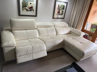 Sofá de piel beige con reposapiés