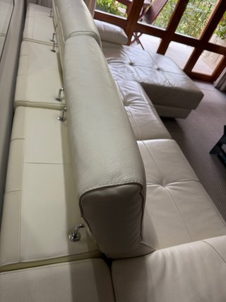 Sofá de piel beige con reposapiés