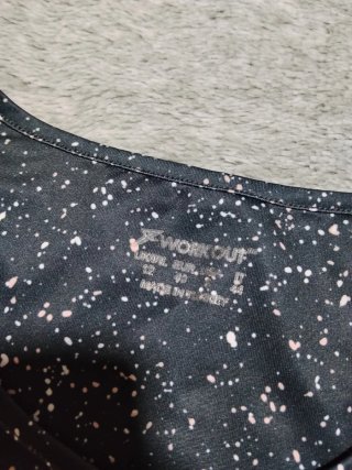 Top deportivo negro con salpicaduras rosas