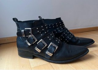 Botines negros planos con tachuelas y hebillas