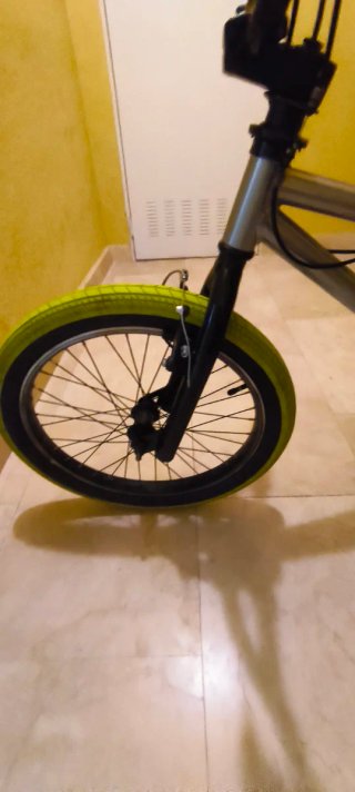 Bicicleta BMX plateada con ruedas verdes