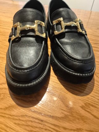 Mocasines de piel negros con hebilla dorada