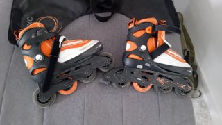 Patines en línea naranjas y negros, con bolsa