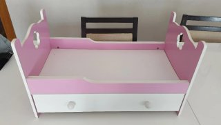 Cama de muñecas rosa y blanca con cajón