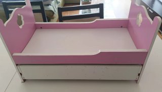 Cama de muñecas rosa y blanca con cajón