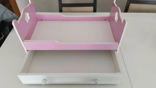 Cama de muñecas rosa y blanca con cajón