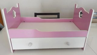 Cama de muñecas rosa y blanca con cajón