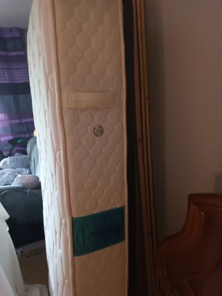 Cama con colchón y cabecero de madera