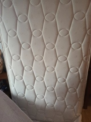 Cama con colchón y cabecero de madera