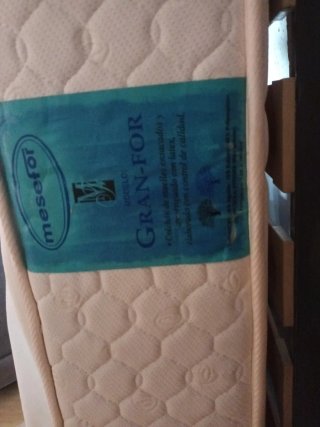 Cama con colchón y cabecero de madera