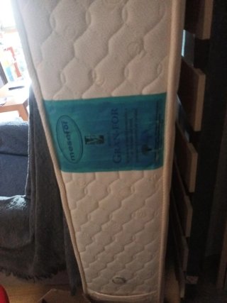 Cama con colchón y cabecero de madera