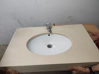 Lavabo de piedra beige con grifo