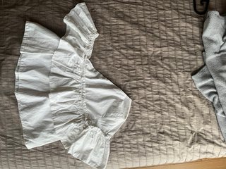 Top blanco hombros desiguales volantes