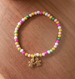 Pulsera elástica con detalle de figuritas doradas.