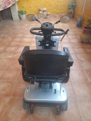 Scooter eléctrico plateado con cesta