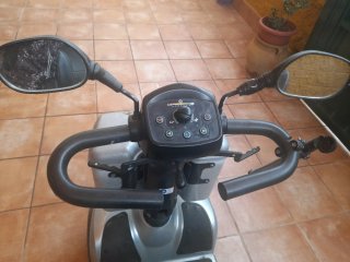 Scooter eléctrico plateado con cesta