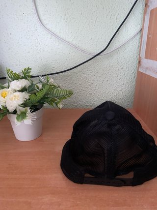 Gorra negra con diseño blanco.