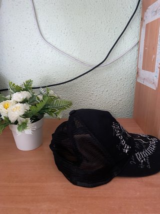 Gorra negra con diseño blanco.