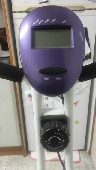 Bicicleta Estática Plegable blanca y morada.