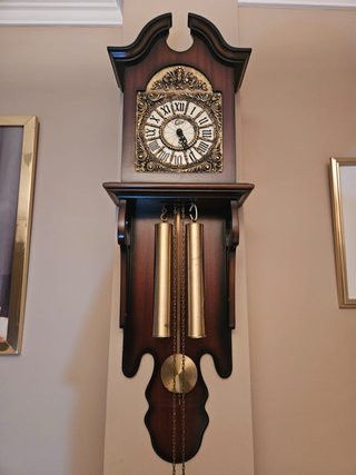Reloj de pared antiguo con péndulo y pesas