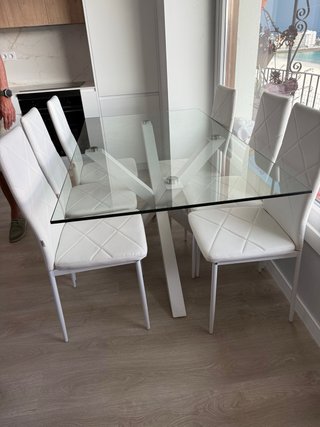 Mesa de cristal con 8 sillas blancas,