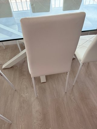 Mesa de cristal con 8 sillas blancas,
