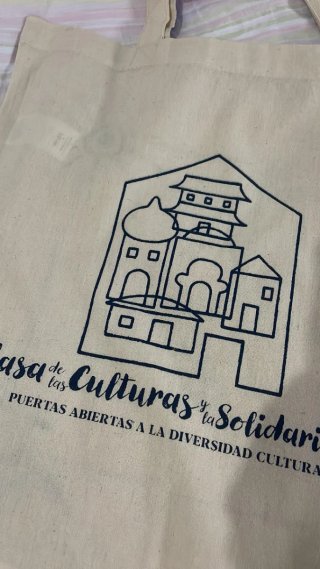 Bolso de tela beige con asas moradas