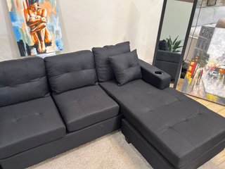 Sofá negro cómodo con portavasos