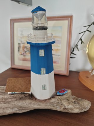 Faro in legno con luce su base di mare