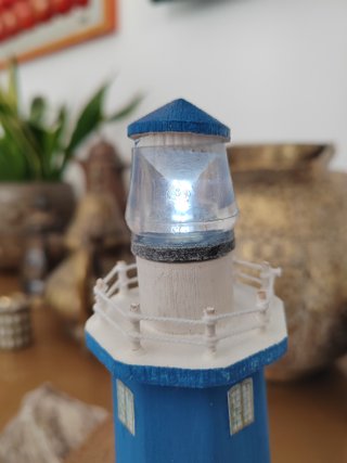 Faro in legno con luce su base di mare