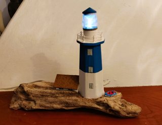 Faro in legno con luce su base di mare