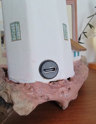 Faro in legno con luce su base di mare