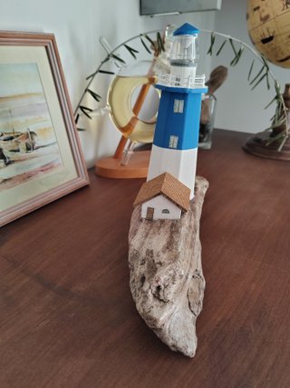 Faro in legno con luce su base di mare