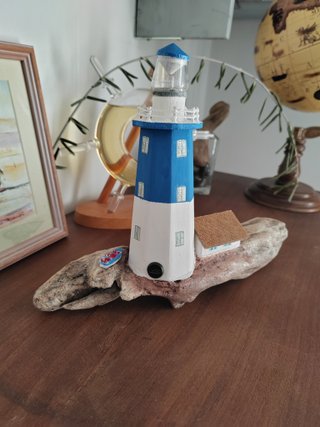 Faro in legno con luce su base di mare