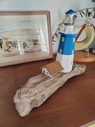Faro in legno con luce su base di mare