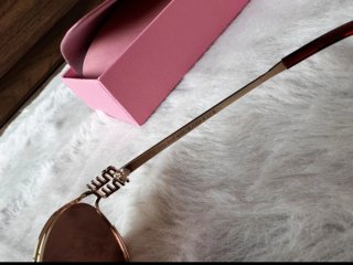 Gafas Miu Miu doradas y marrones