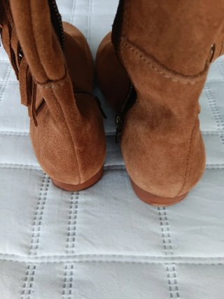 Botas de ante con flecos y hebilla.