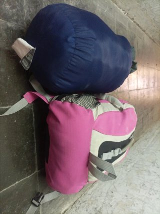 Set mochila rosa y saco de dormir azul senderismo
