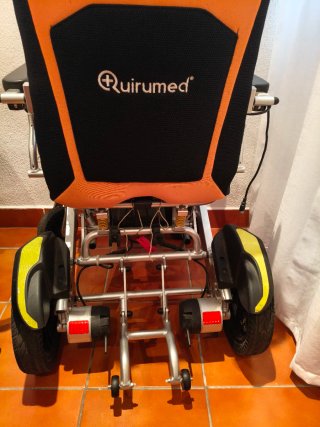 Silla de ruedas eléctrica naranja y negra