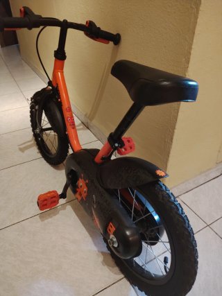 Bicicleta infantil naranja con ruedines