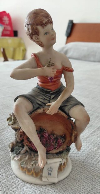 Statuina porcellana con giovane in vendemmia