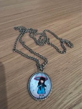 Collar con colgante de niña bajo la lluvia