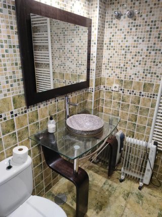 Lavabo de piedra sobre mueble de cristal