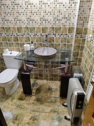 Lavabo de mármol sobre mueble de cristal