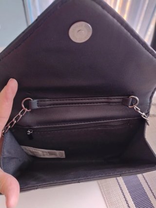 Bolso negro con tachuelas y perforaciones