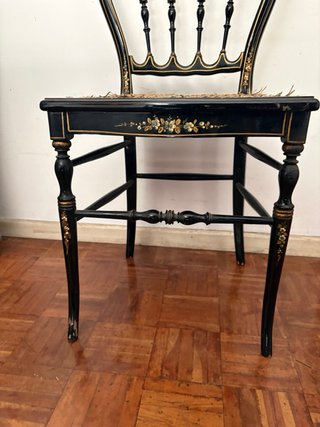 Silla antigua negra con detalles dorados