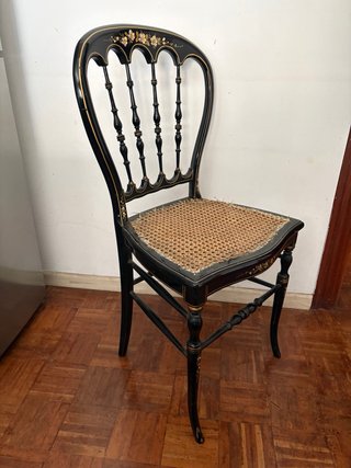 Silla antigua negra con detalles dorados