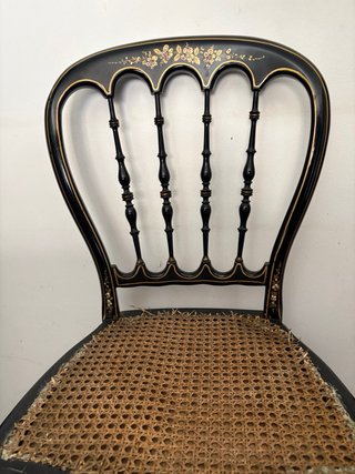 Silla antigua negra con detalles dorados