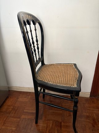 Silla antigua negra con detalles dorados