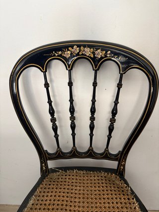 Silla antigua negra con detalles dorados